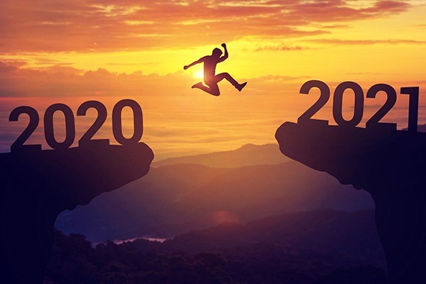 A man jumping on the rocks where the big numbers 2020 and 2021 stand