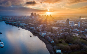 London, England – Panoramic aerial skyline view of east London at sunrise with skycrapers of Canary Wharf